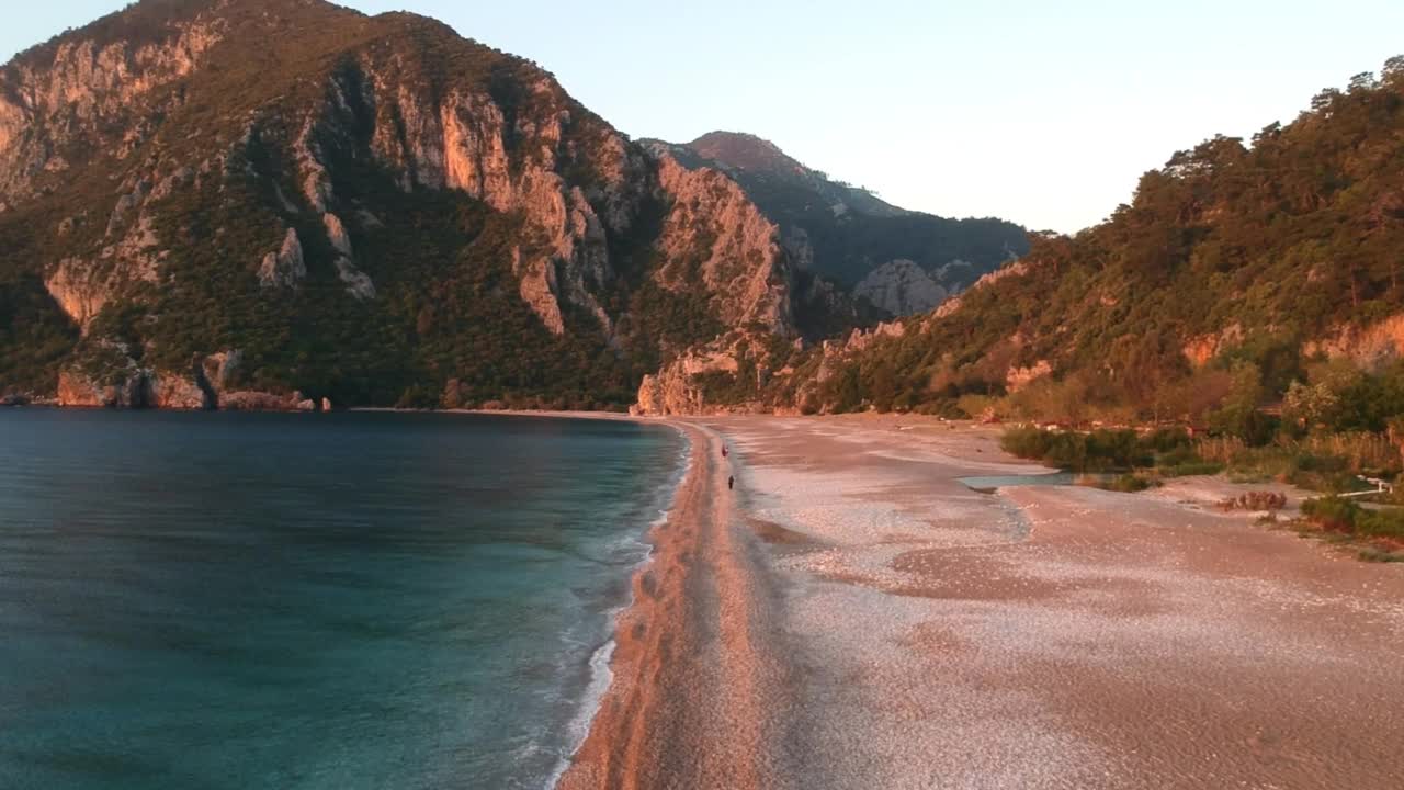 在落日的余晖中，从高空俯瞰西拉利海滩和奥林波斯山。凯默，安塔利亚，地中海地区，土耳其，莱西亚。视频素材