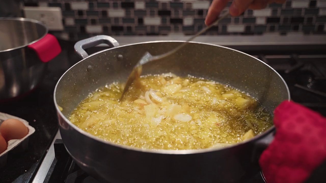 用橄榄油煎土豆和洋葱做西班牙煎蛋卷视频素材