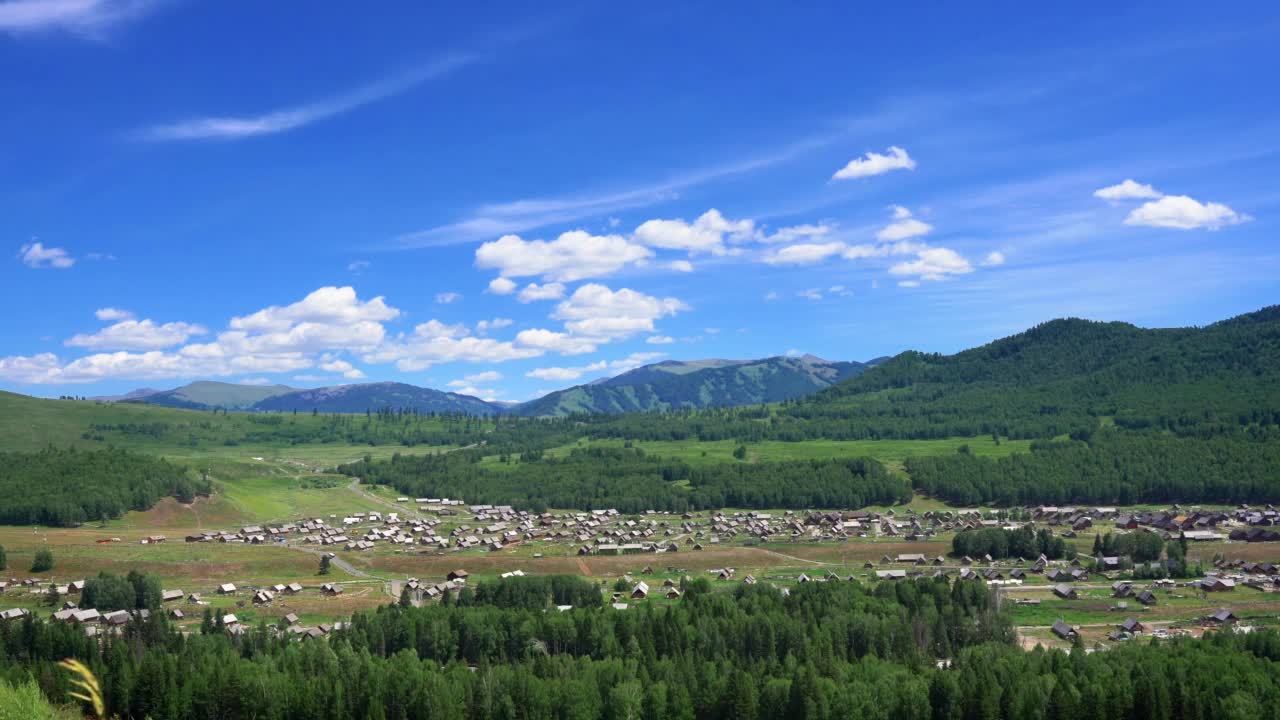 在多云的蓝天下，俯瞰青山山坡上的乡村房屋视频素材