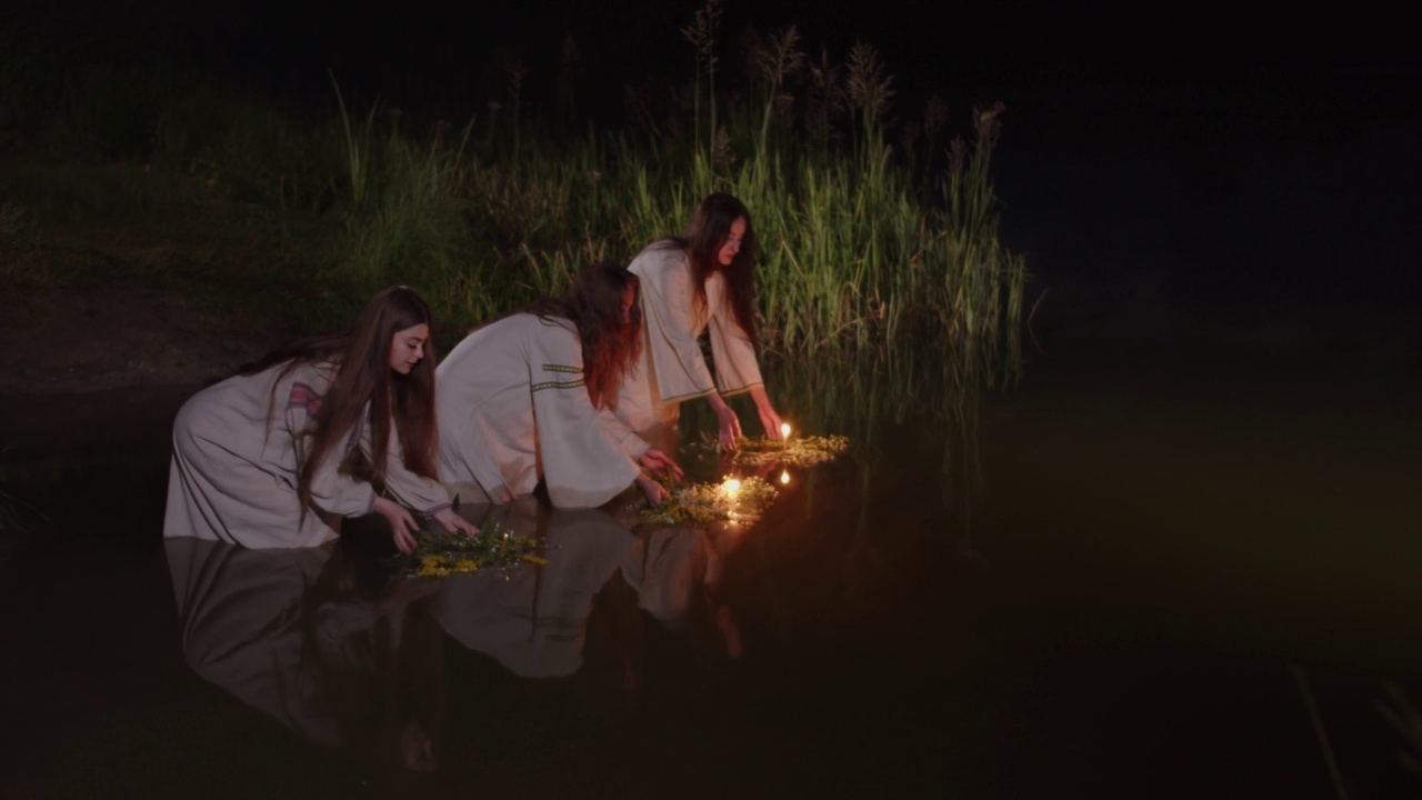 女孩们把野花编成的花圈扔进水里视频素材