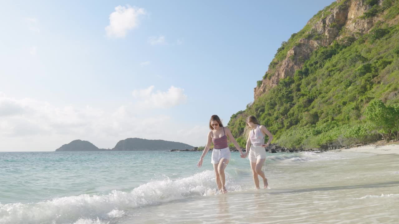 两位亚洲女博主在海上小岛的海滩旅行中，用动作相机向朋友们炫耀自己的自由、旅行、冒险的概念视频素材