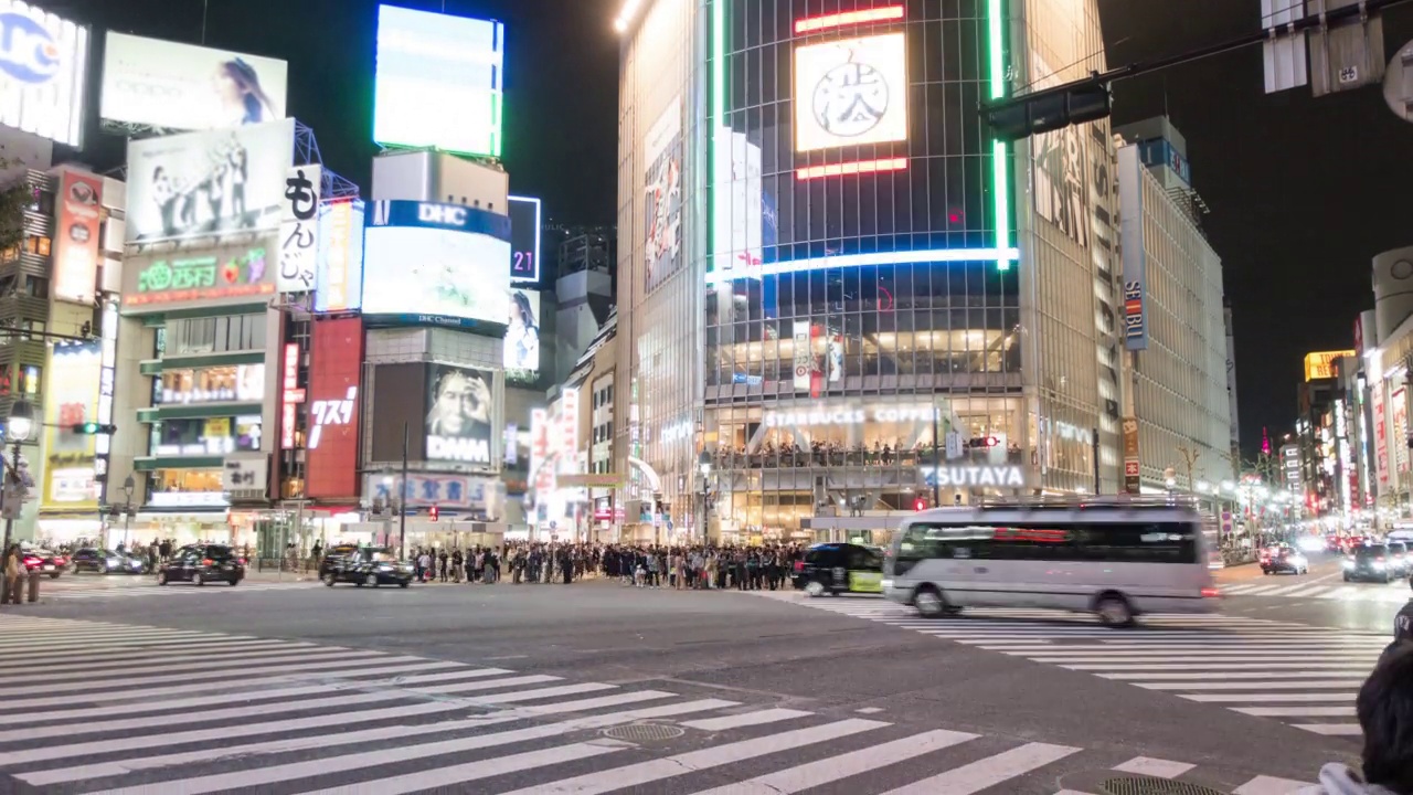 夜间，日本东京涩谷十字路口，许多行人和车辆通过路口视频素材