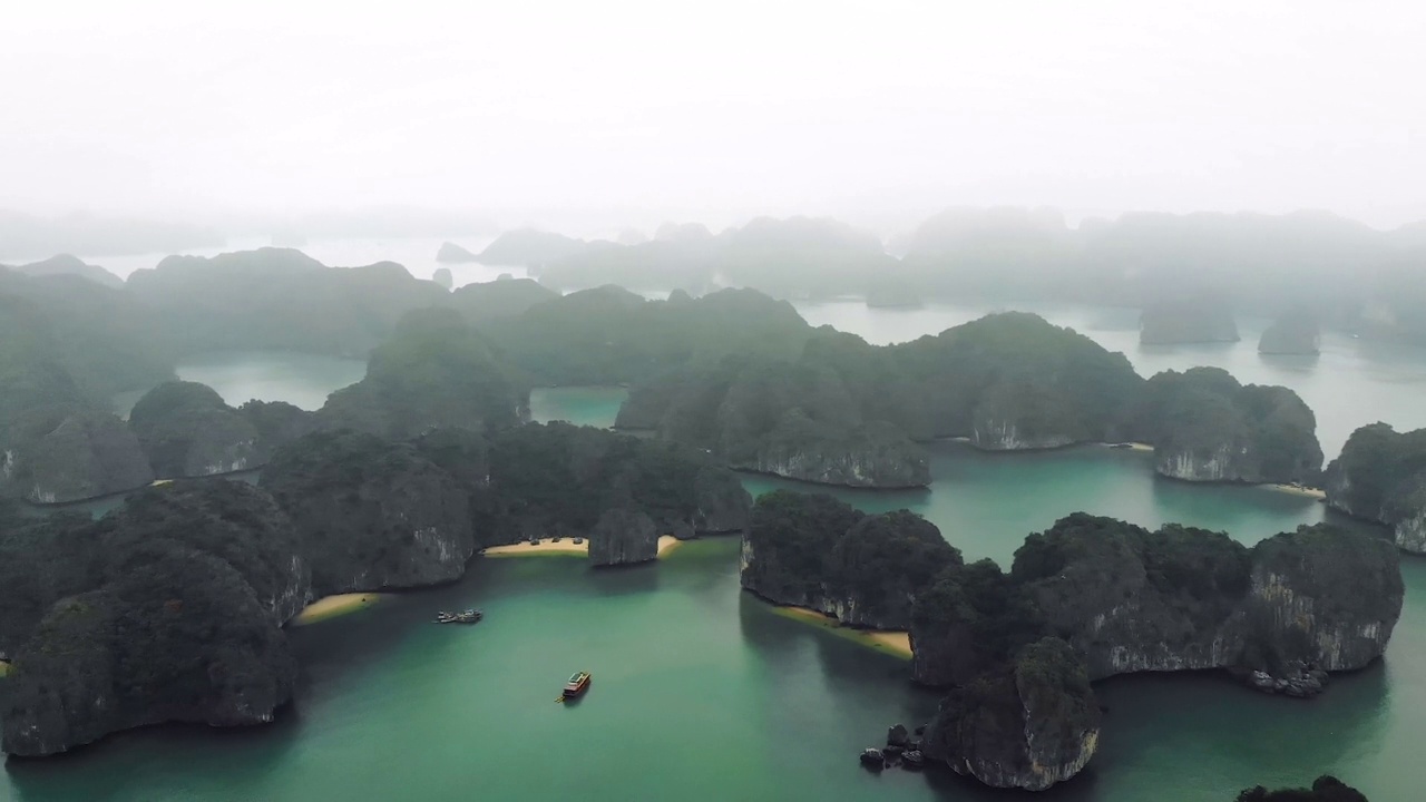 令人惊叹的越南下龙湾。雾霾天气下，下龙游船穿过世界著名的海湾。令人惊叹的风景游轮。来自四轴飞行器无人机的视频视频素材