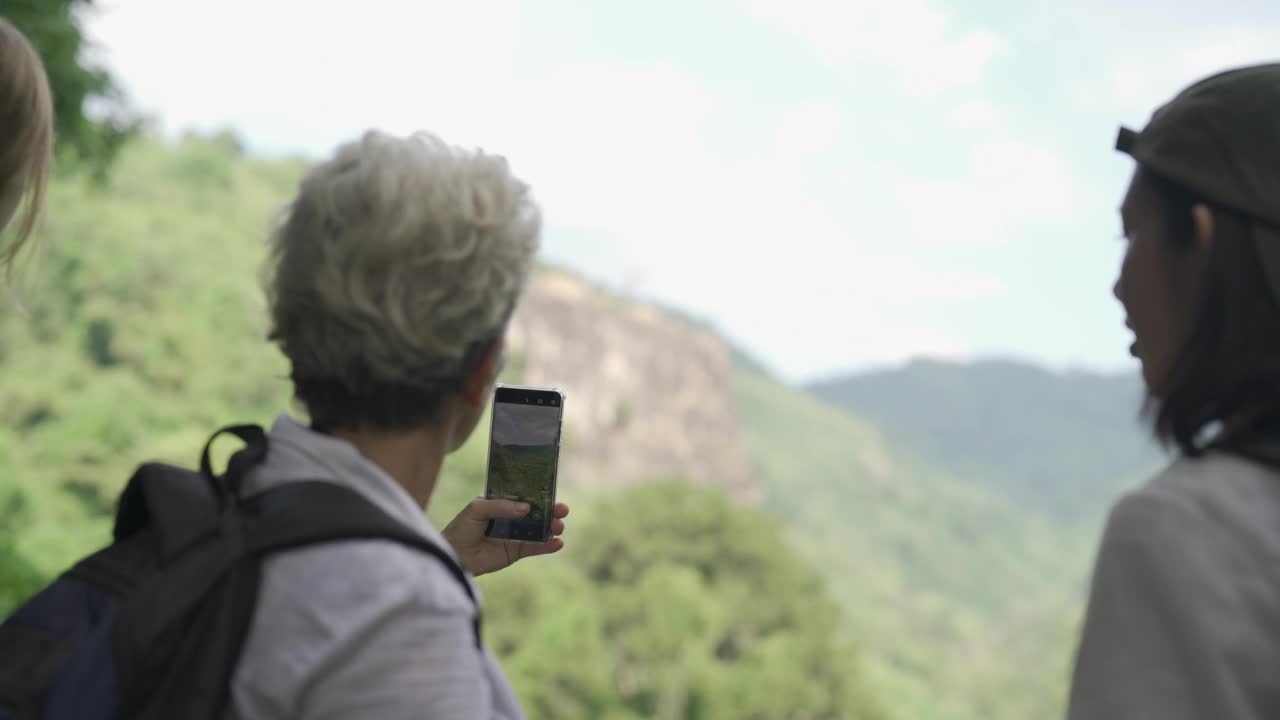 一位女士愉快地用手机拍照视频素材