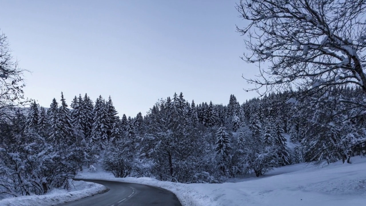 在冬天，沿着日出时的雪景拍摄山路边的超延时视频下载