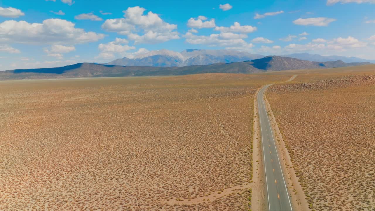 这条路穿过美国荒凉的平原。风景如画的山脉行程为加州到内华达州在阳光明媚的白天。视频素材