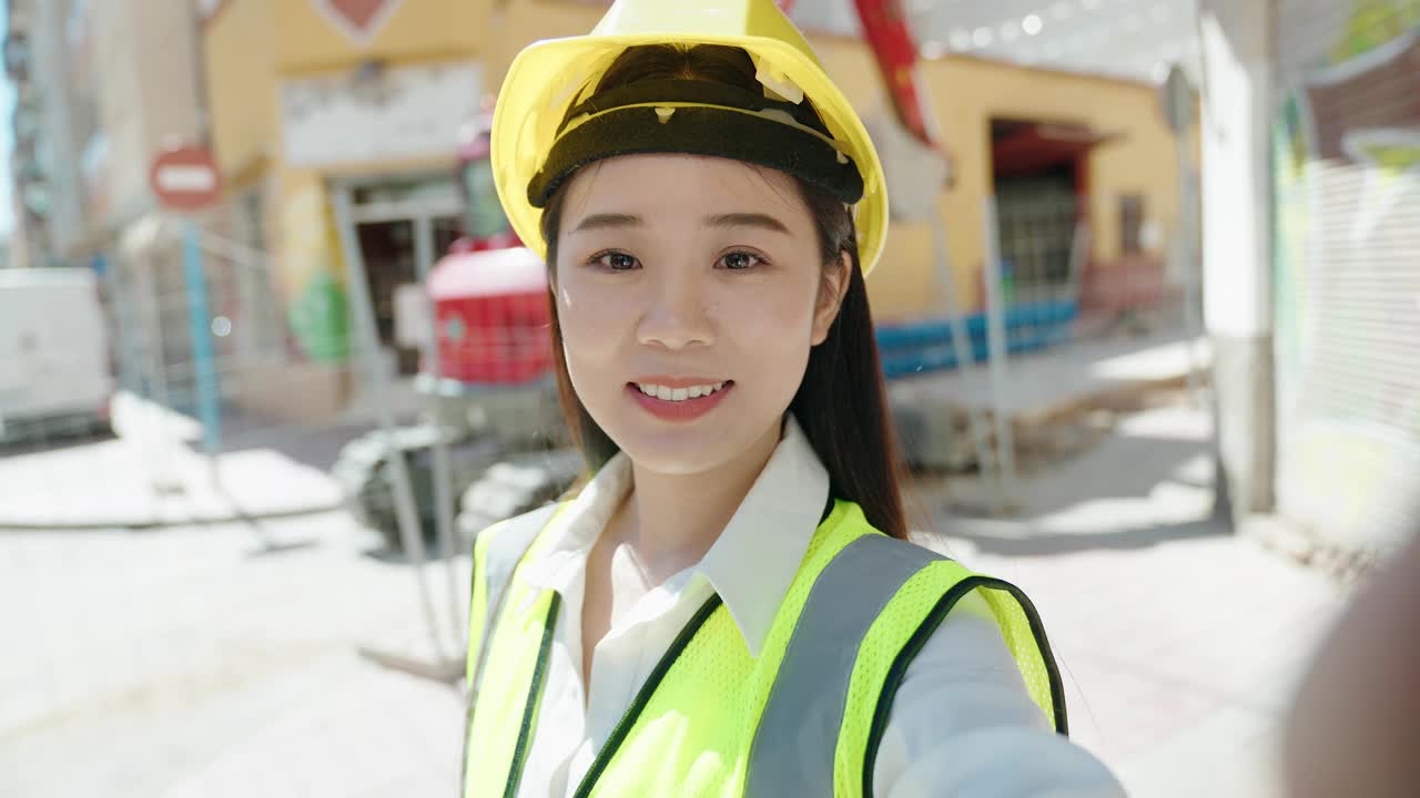 年轻的中国女建筑师微笑着自信地在街上视频通话视频素材