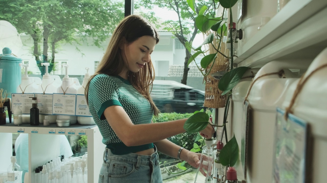 一名女顾客在商店里用可重复使用的容器装肥皂液。视频素材