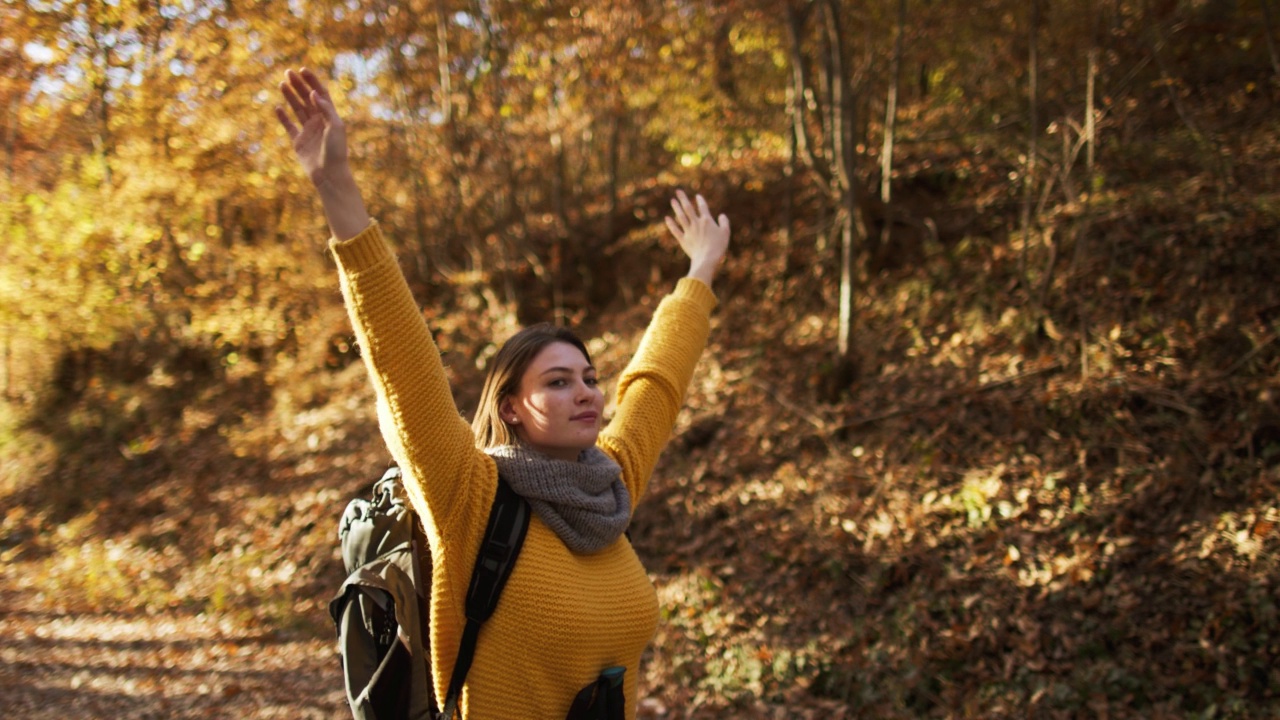 年轻女子在秋天大自然阳光明媚的日子里徒步旅行视频素材