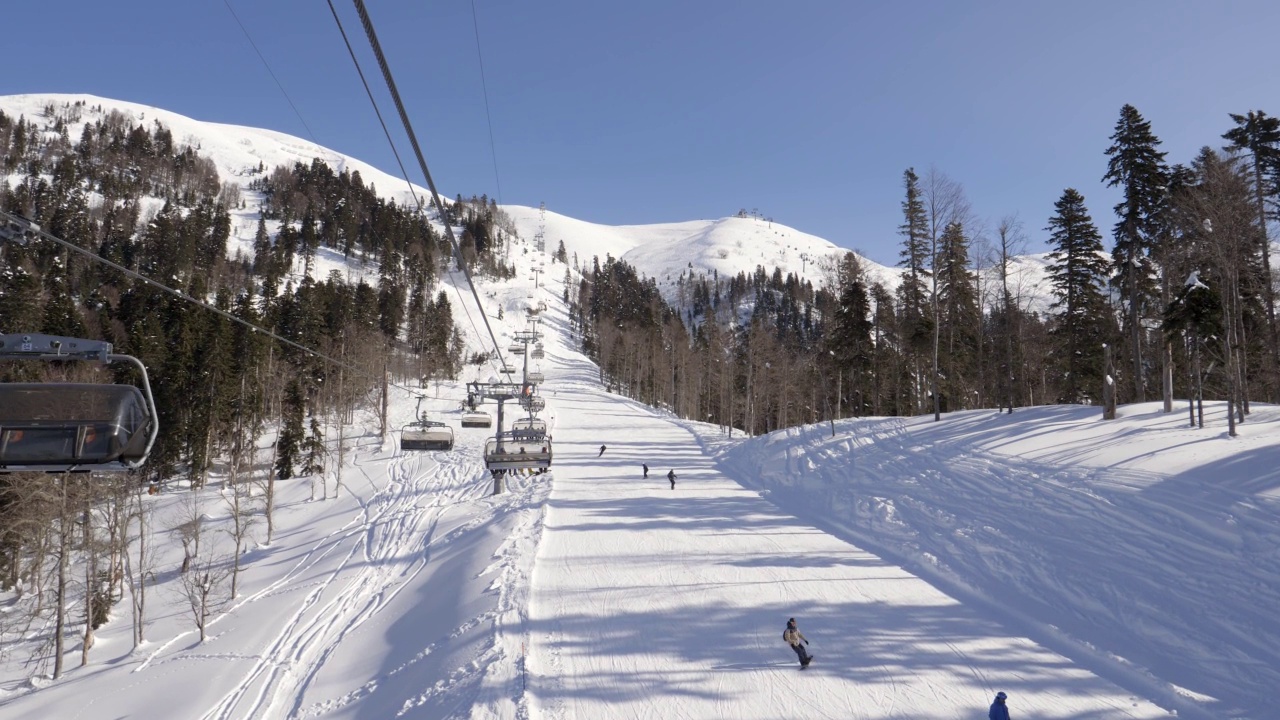 滑雪者坐在滑雪缆车上攀登山峰视频素材