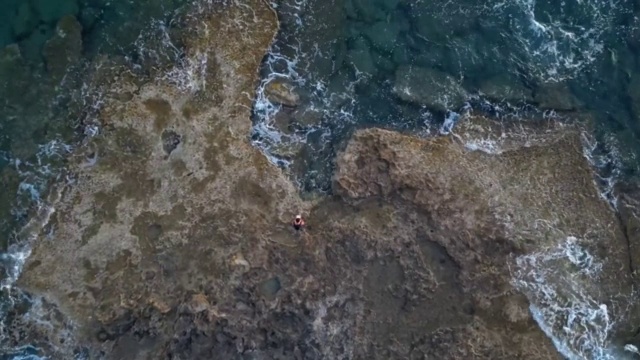 从鸟瞰图上可以看到拍打岩石海岸的浪花视频素材