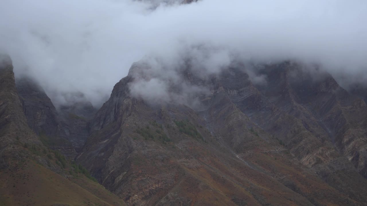 在印度喜马偕尔邦拉豪尔斯皮提地区的坦迪，暴风雨天气期间山顶周围的雾4K拍摄。云在山顶上翻滚。自然背景。视频素材