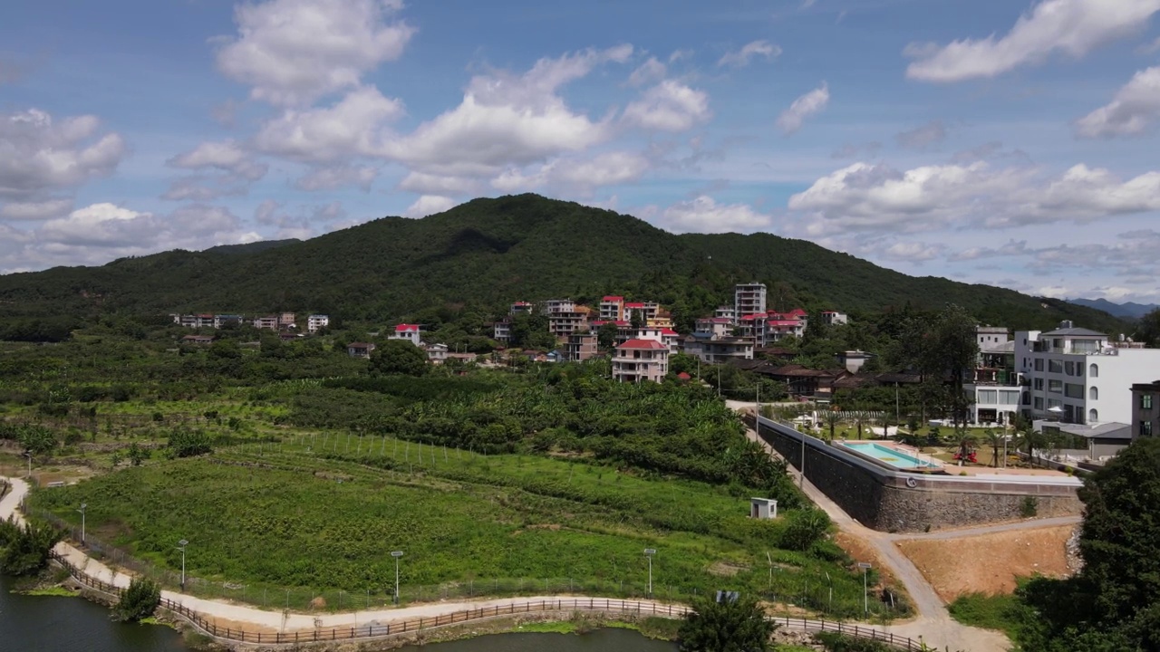 在一个阳光明媚的日子里，山上的村庄在河边视频素材