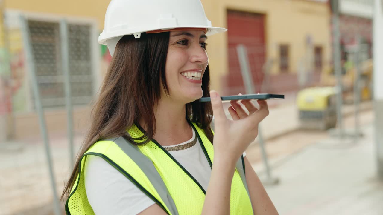 年轻美丽的西班牙女建筑师微笑着自信地在街上用智能手机聊天视频素材