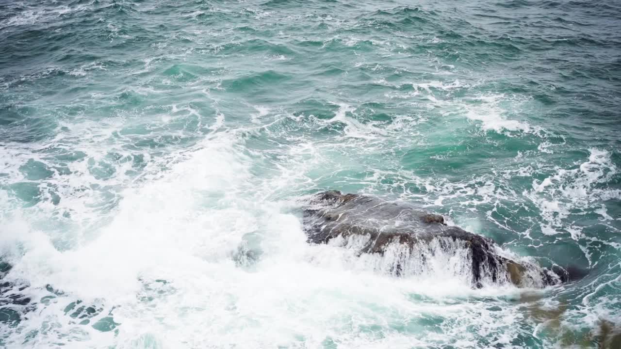 海浪撞击着海里的一块大石头。视频素材