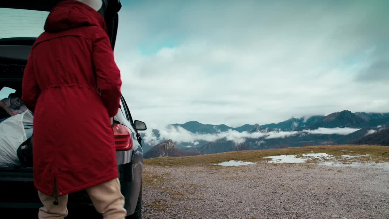 女旅行者在公路旅行中走到山边，成功地举起了手视频素材