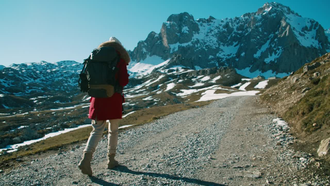 女游客背着背包走在美丽的山路上度假旅行视频素材