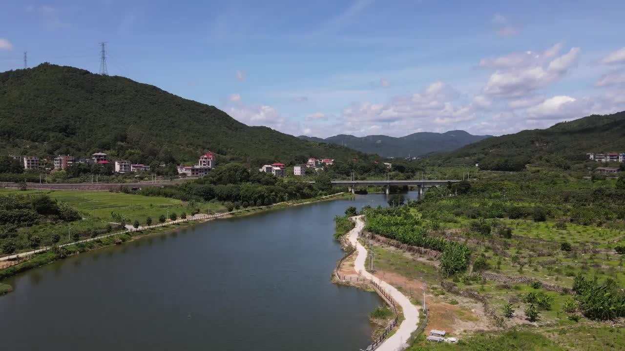 在一个阳光明媚的日子里，山上的村庄在河边视频素材