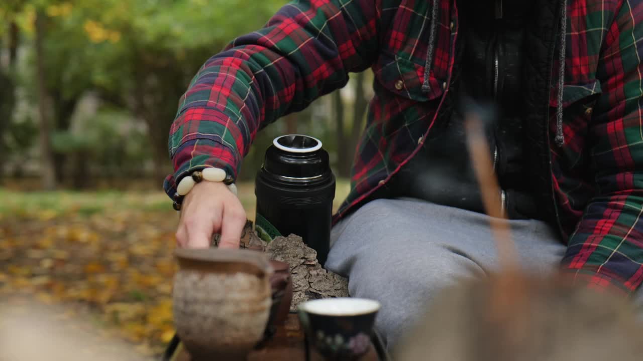 一名男子将深色的普洱茶从陶制茶壶倒入特制的陶制壶中视频素材