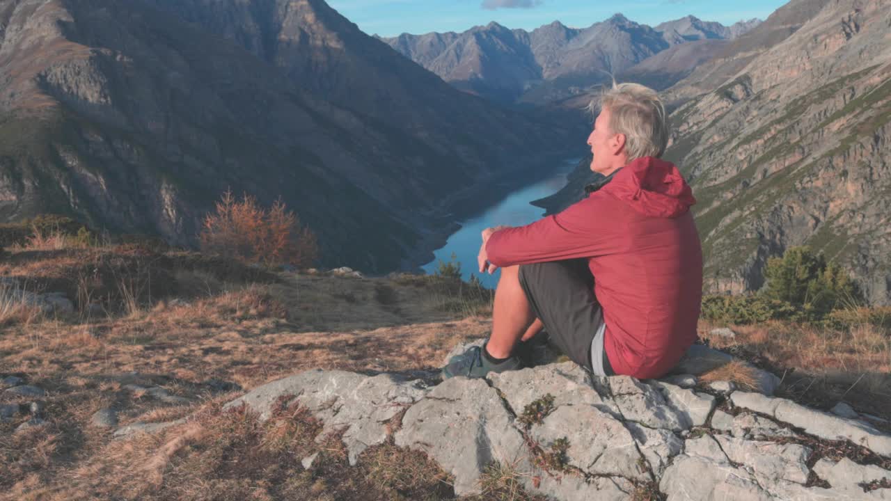 成熟的登山男性在登山山顶放松，望向远方视频素材