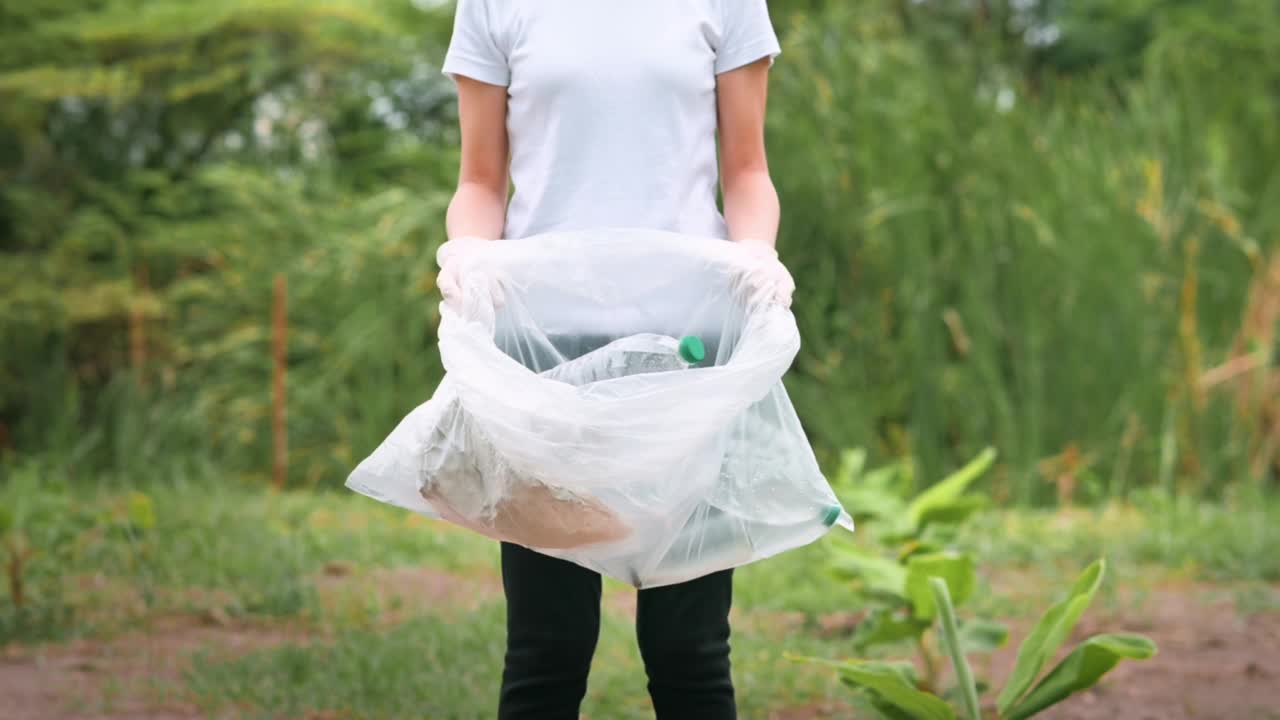 妇女在地上收集回收垃圾，生态可持续的理念。视频素材