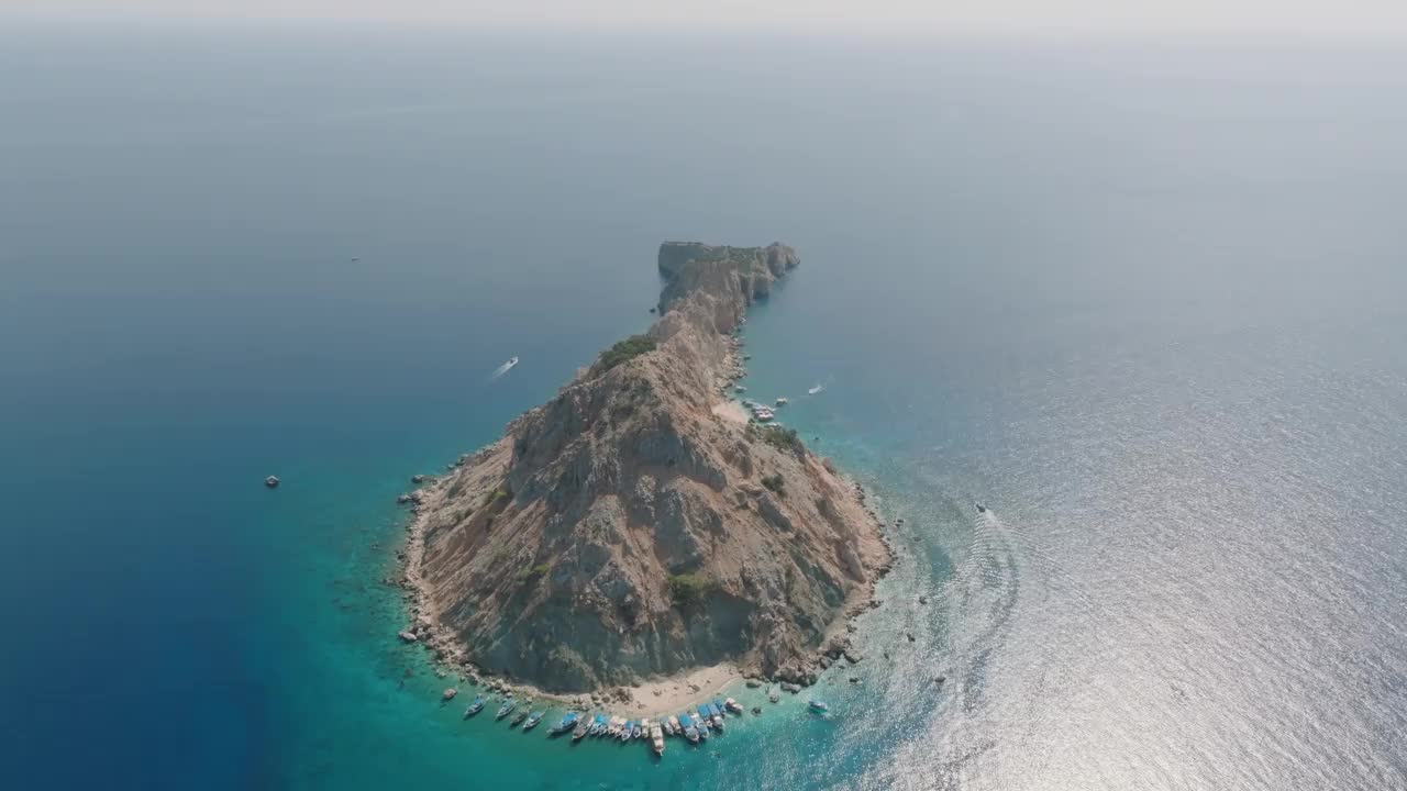 苏卢亚达-安塔利亚鸟瞰图，绿松石海的岛屿，岛上停靠的游船和人们在游泳，人们在绿松石水里游泳，白沙海滩，干净的海滩，著名的海滩和安塔利亚岛视频素材