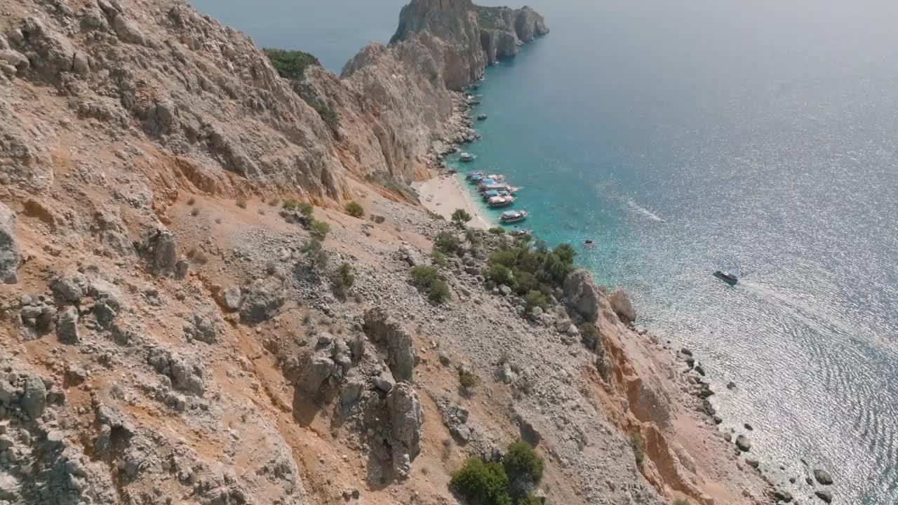 苏卢亚达-安塔利亚鸟瞰图，绿松石海的岛屿，岛上停靠的游船和人们在游泳，人们在绿松石水里游泳，白沙海滩，干净的海滩，著名的海滩和安塔利亚岛视频素材