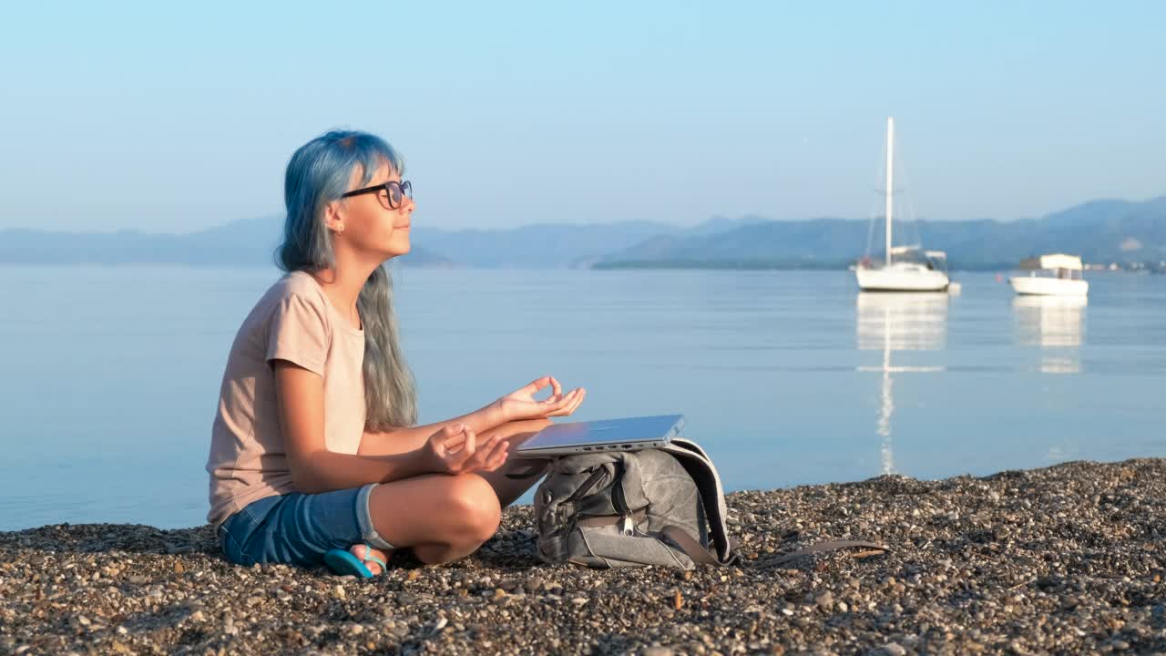 女孩在平静的海浪中冥想。视频素材