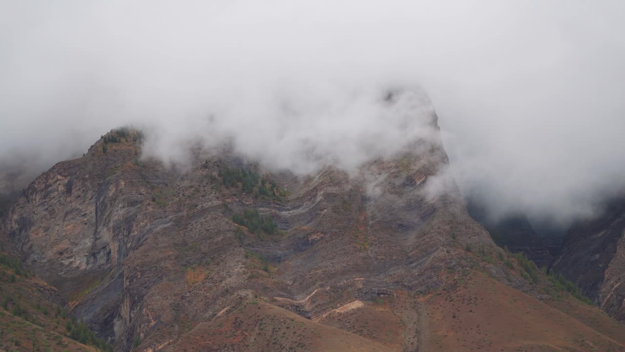 在印度喜马偕尔邦拉豪尔斯皮提地区的坦迪，暴风雨天气期间山顶周围的雾4K拍摄。云在山顶上翻滚。自然背景。视频素材