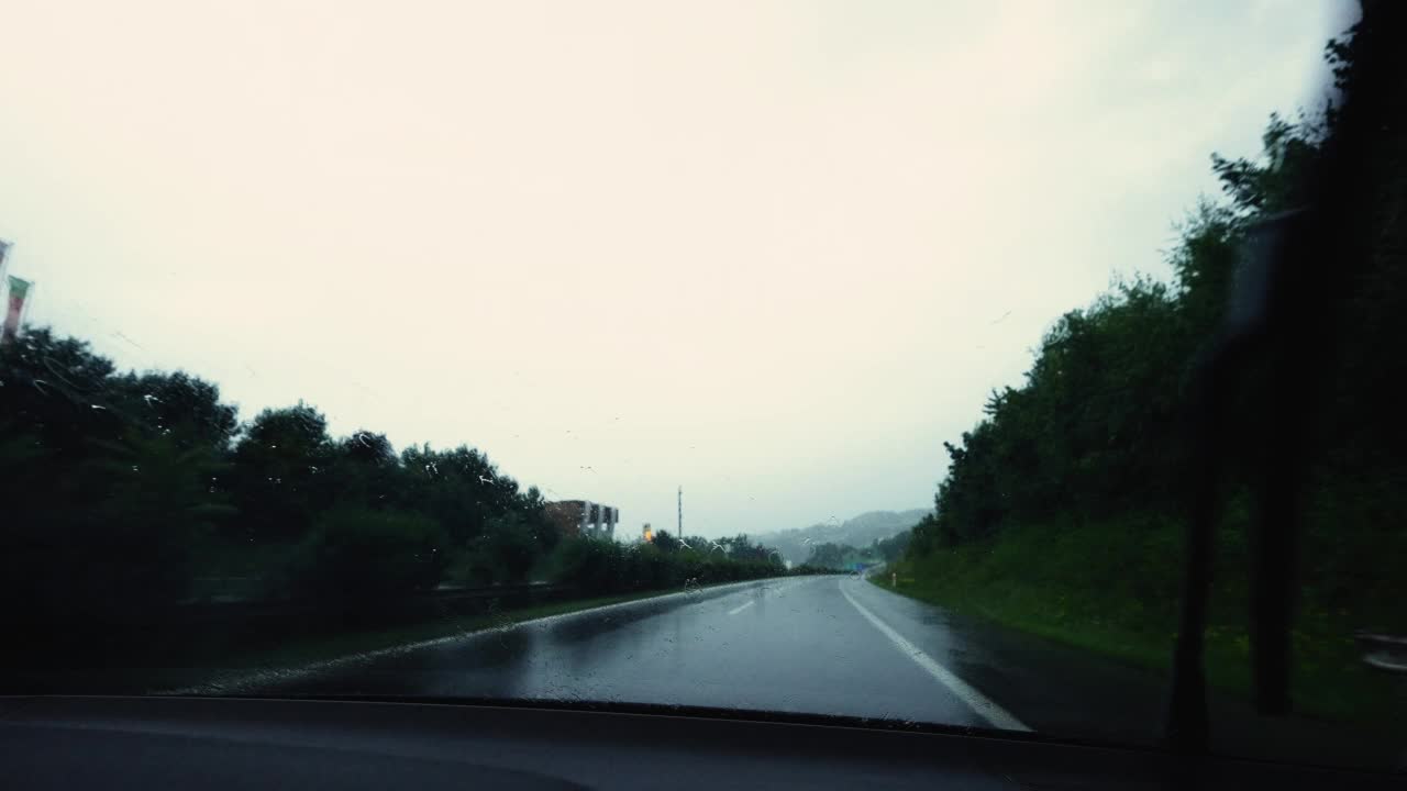 阴天，恶劣天气下高速公路汽车挡风玻璃行驶特写。车辆在雨中行驶视频素材