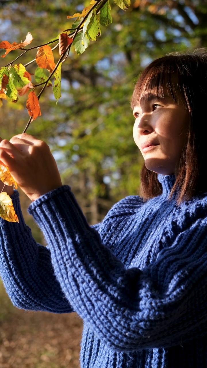 女子在公园里享受秋天。视频素材