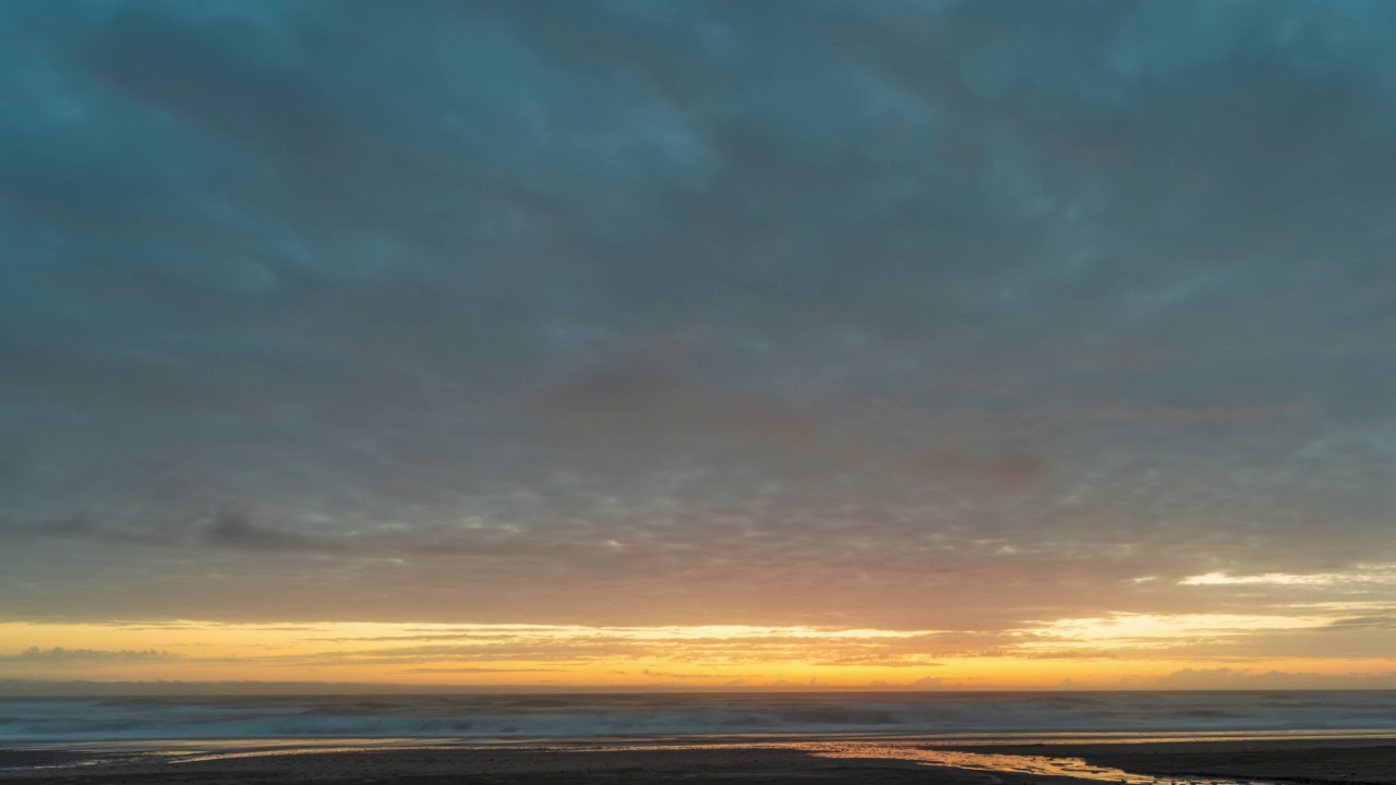 在黄色的日落期间，海滩上的云-时间流逝视频下载