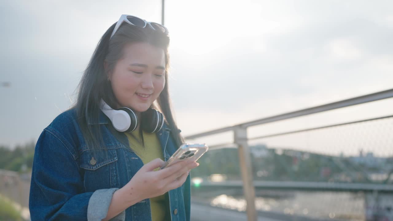 快乐的亚洲女性游客旅行者独自在街上旅行使用智能手机享受假期度假旅行的时间视频素材