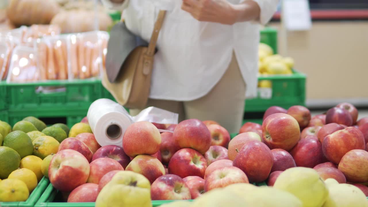 一个女人在杂货店买红苹果视频素材