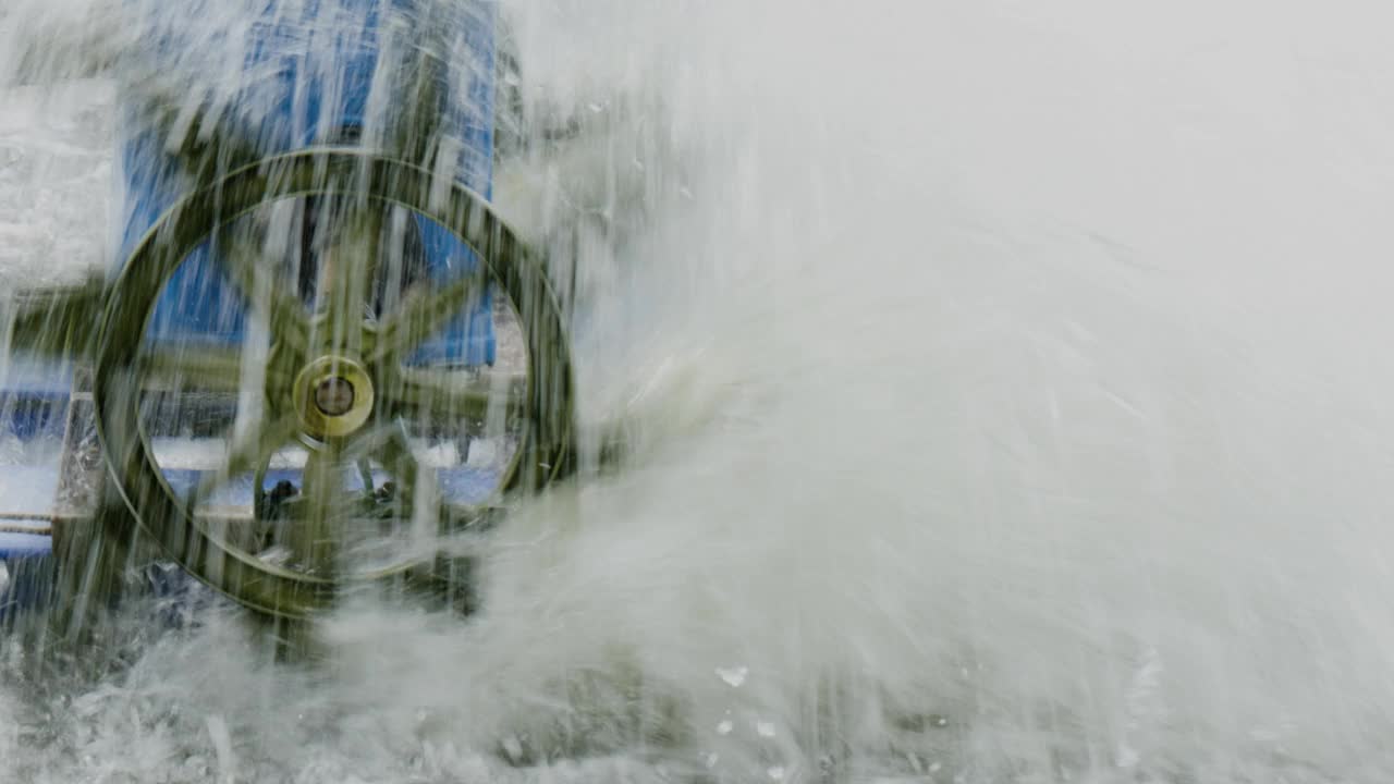 在水中旋转的水轮会在水中产生波纹和气泡视频素材
