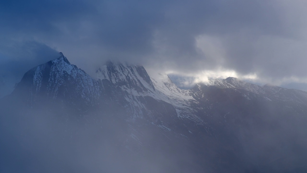 白雪皑皑的高山山峰从云层中露出视频素材