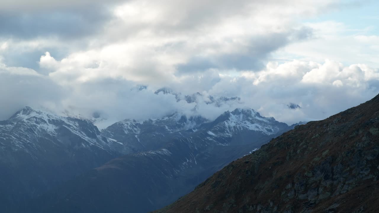 暴风雨散去后，高山山峰从云层中显现的景象视频素材