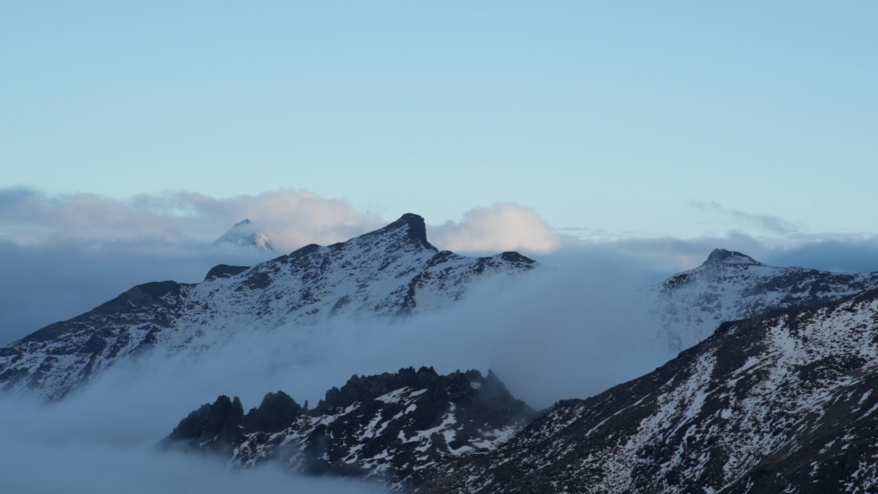 暴风雨散去后，高山山峰从云层中显现的景象视频素材