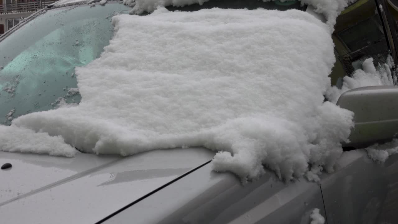 男子清理汽车挡风玻璃上的冰雪视频素材