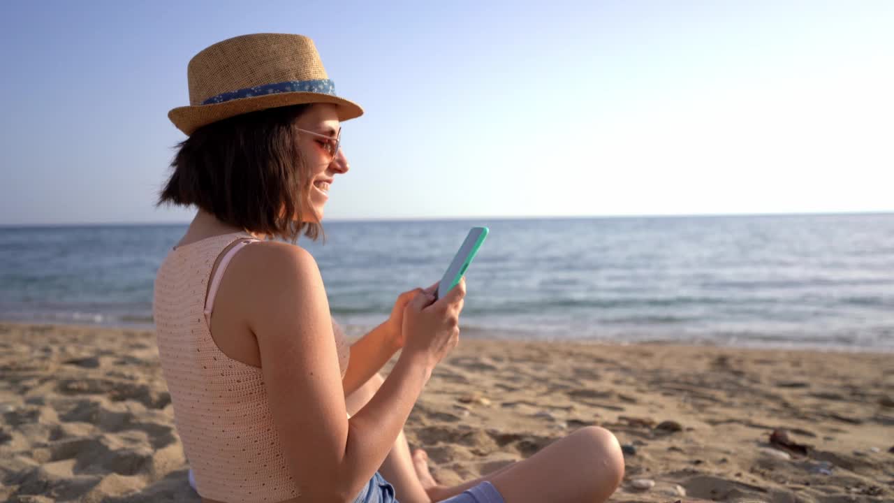 在海滩上用智能手机的女人视频素材