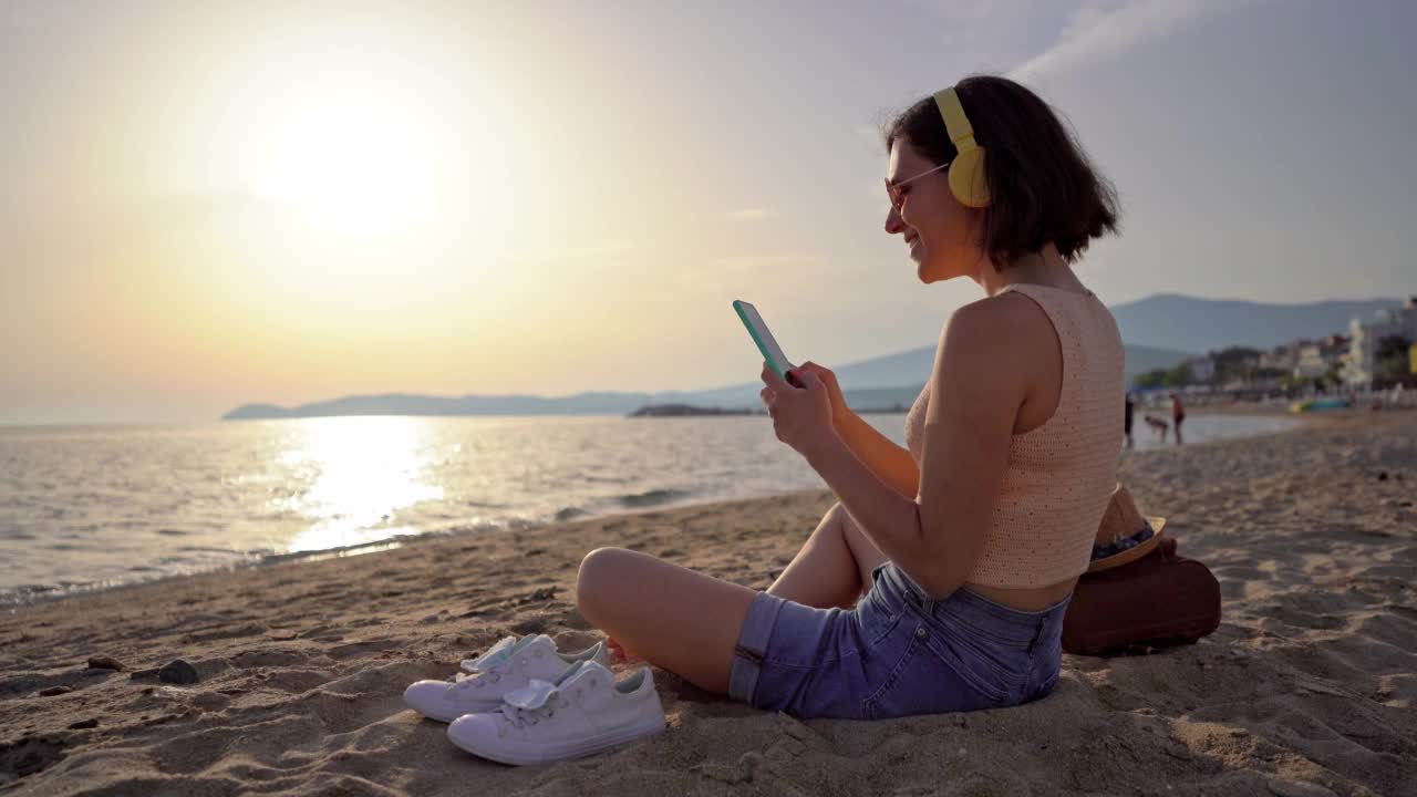 在海滩上用智能手机的女人视频素材