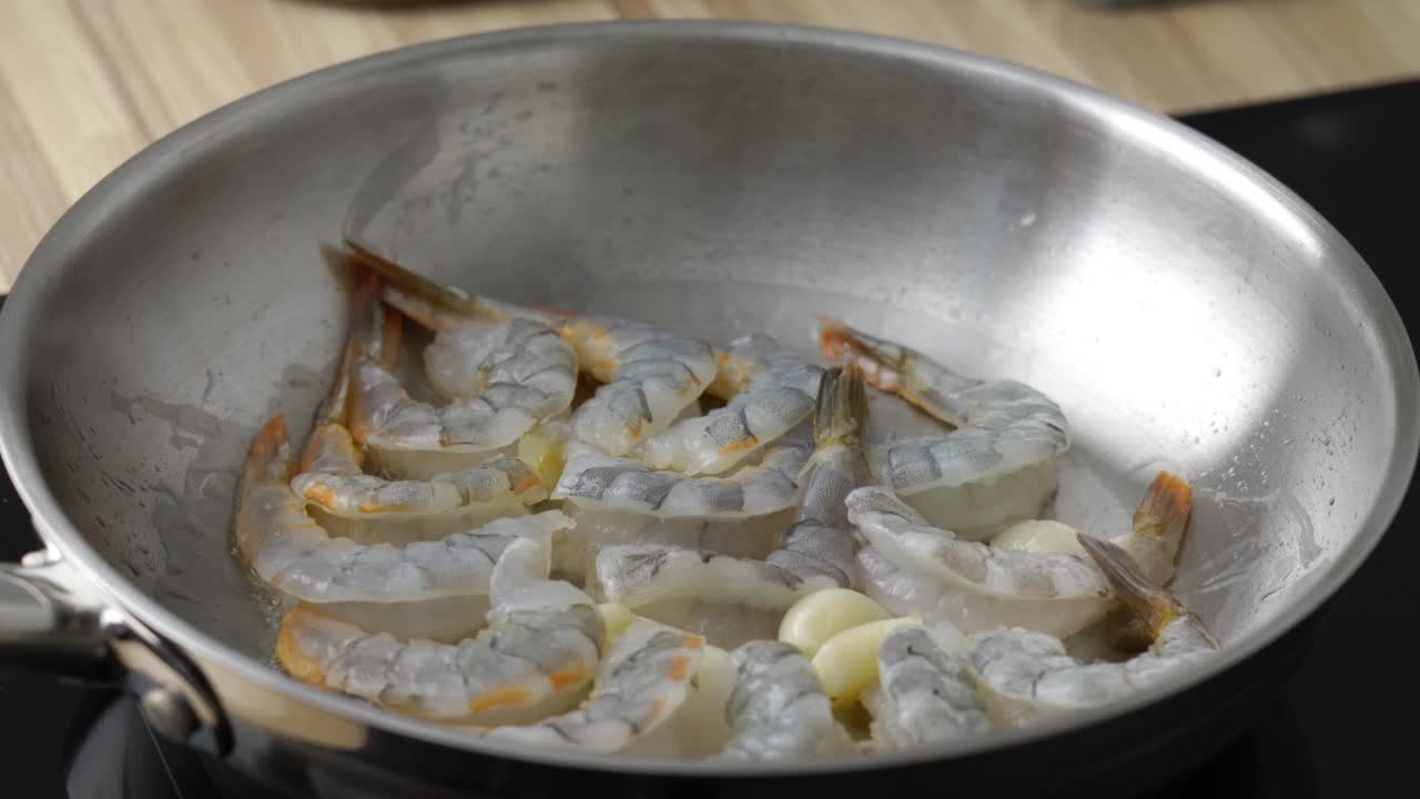 虾和海鲜在平底锅上煎。浇上细细的橄榄油。生酮餐炸虾生酮饮食，准备酱料意大利面，海鲜虾在金属煎锅中滋滋作响，热平底锅油炸富含胆固醇的旧石器食物视频下载