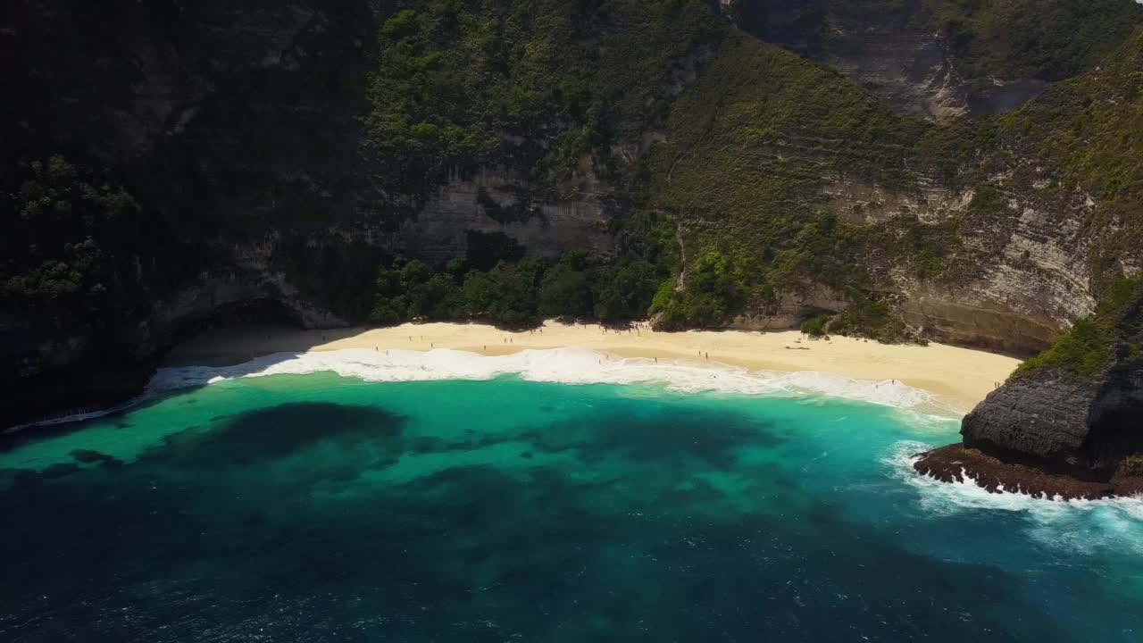 无人机的画面。海洋中的热带岛屿。清澈的蓝绿色海水拍打着岩石和岛上的沙滩。Nusa Penida岛上Kelingking海滩的风景。旅行的概念视频素材