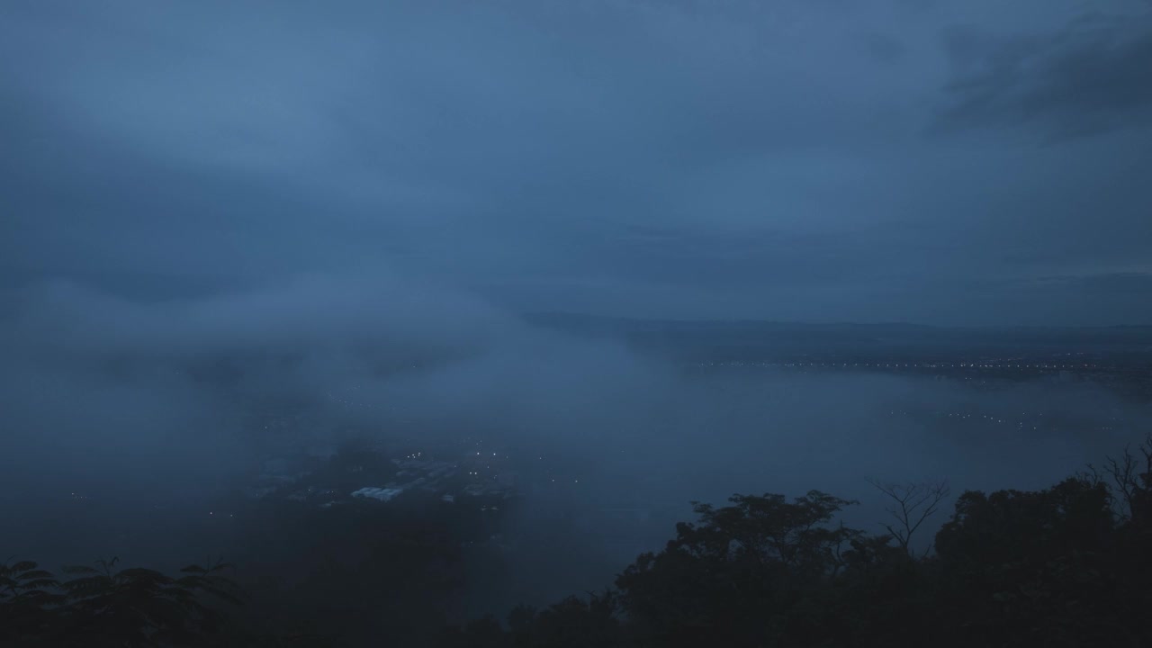 黄昏时分的薄雾在城市上空飘过，然后消失。雾笼罩着城市，城市笼罩在雾中。移走了。视频素材