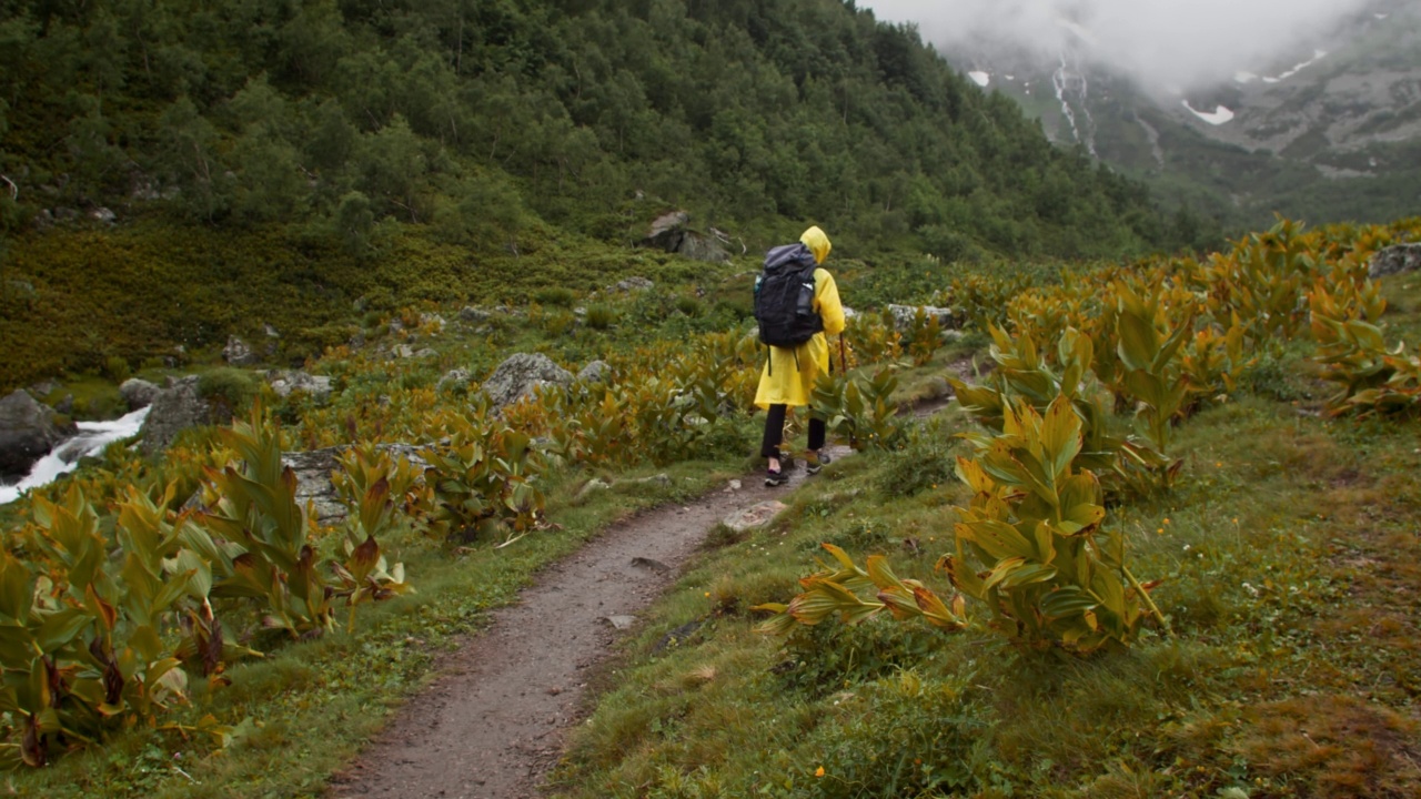 下雨天走在山谷里的女旅行者视频素材