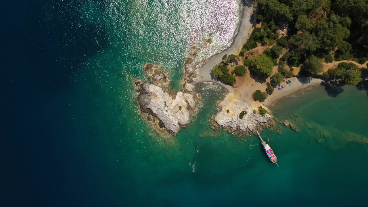 地中海海景与蓝绿色的水和岩石海岸的鸟瞰图。泻湖上的观光游船视频素材