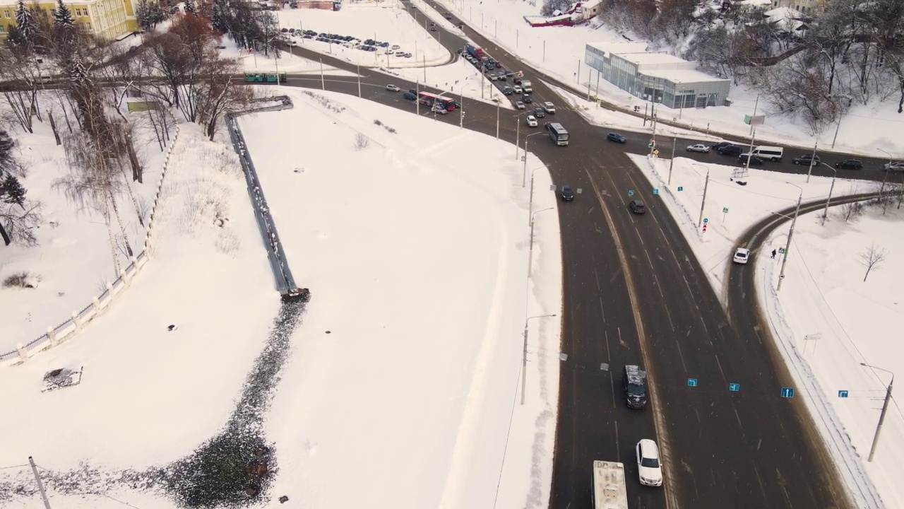 从鸟瞰城市道路上的汽车，积雪。视频素材