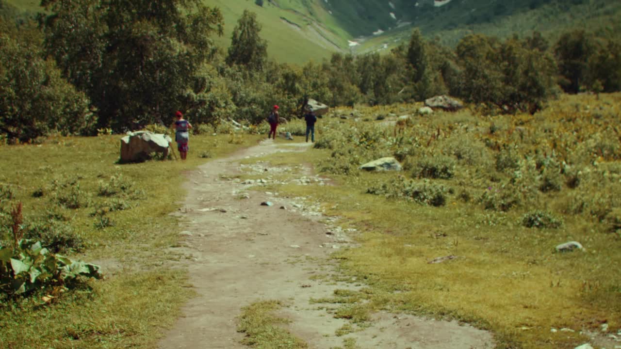 年轻女子走在阳光明媚的山谷向山视频素材