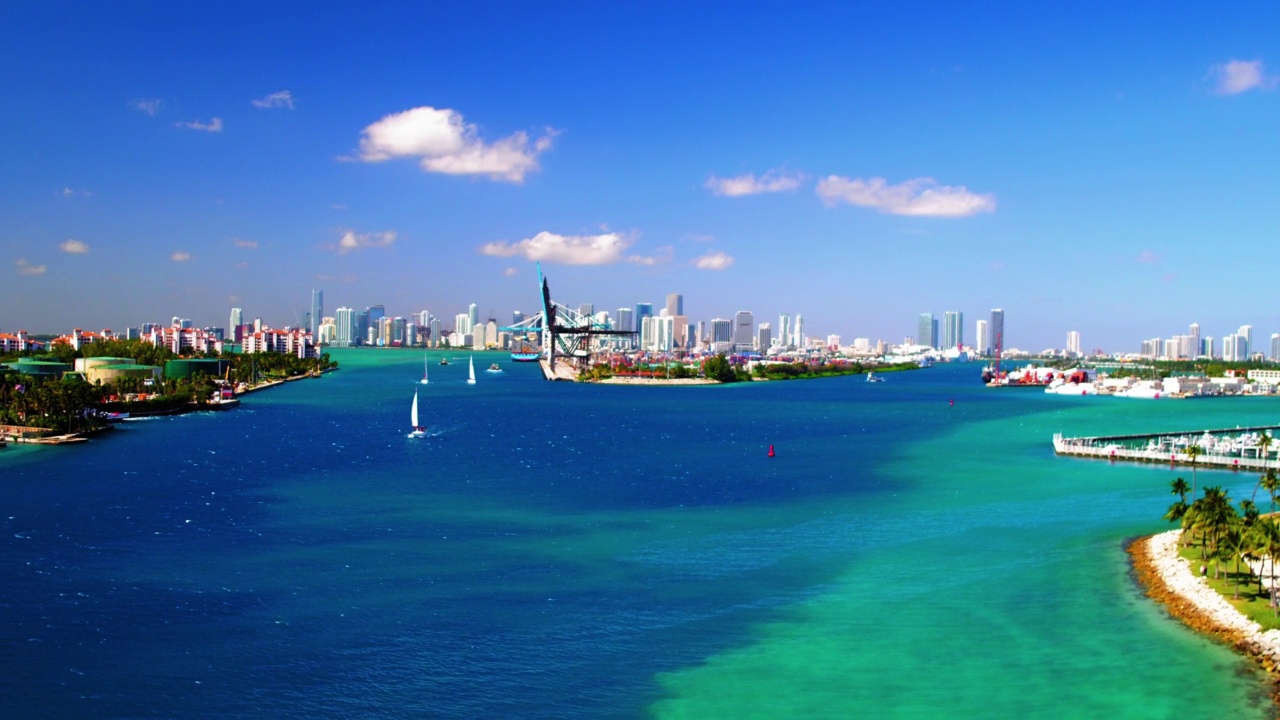 空中拍摄的海港在蓝色的大海上，现代城市对着天空，无人机在阳光灿烂的日子向后飞行-迈阿密，佛罗里达州视频素材