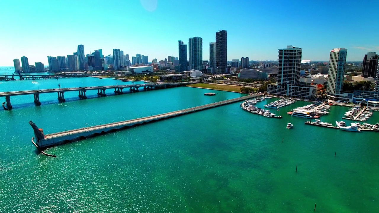 空中封锁拍摄的海港，海上的桥梁，摩天大楼在晴朗的天空下的城市-迈阿密，佛罗里达州视频素材